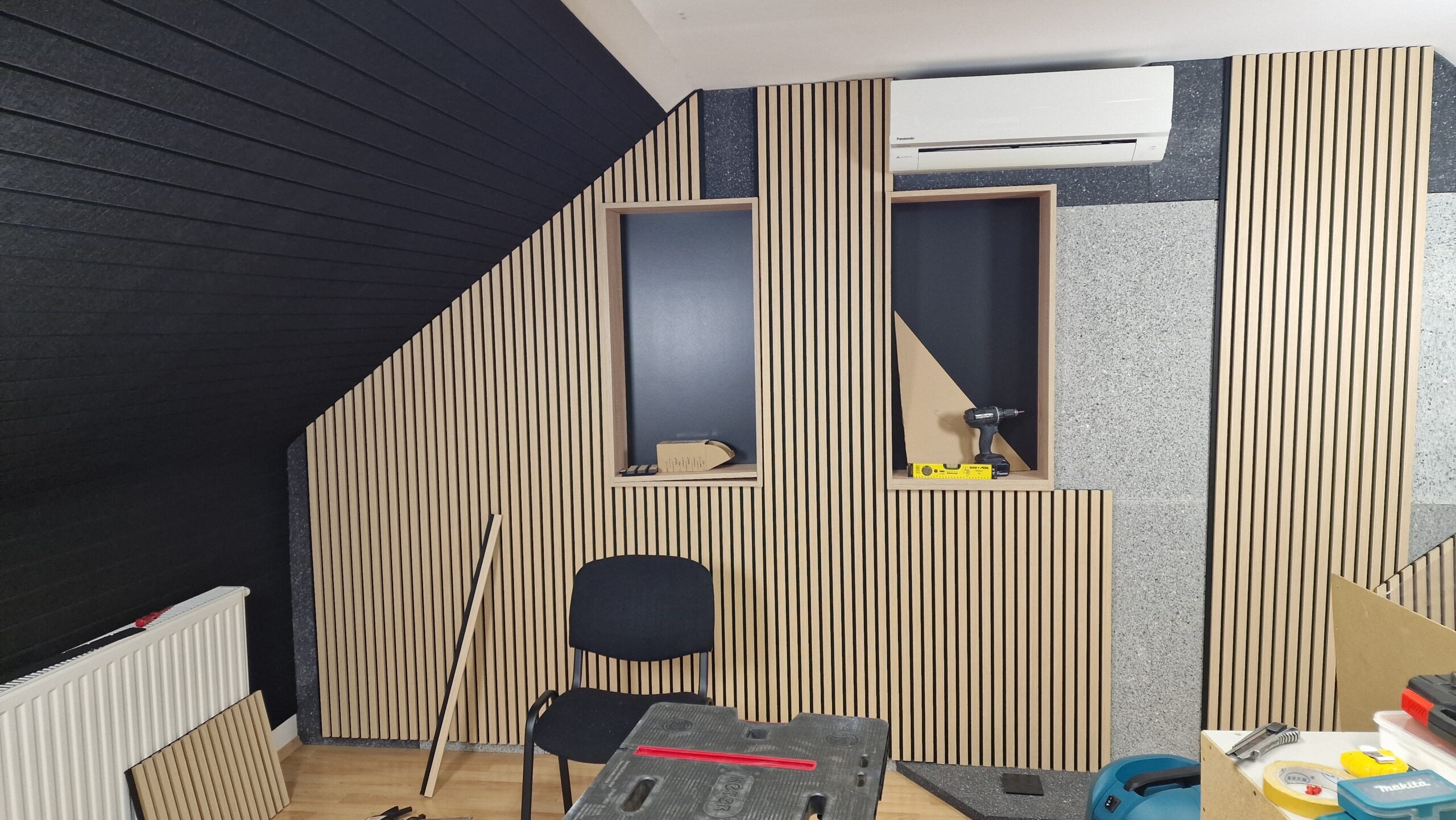 Wood slat acoustic panels installed on a sloped ceiling for effective ceiling soundproofing.