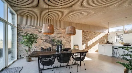 Wooden slat ceiling soundproofing panels in a modern open-plan living and dining area.